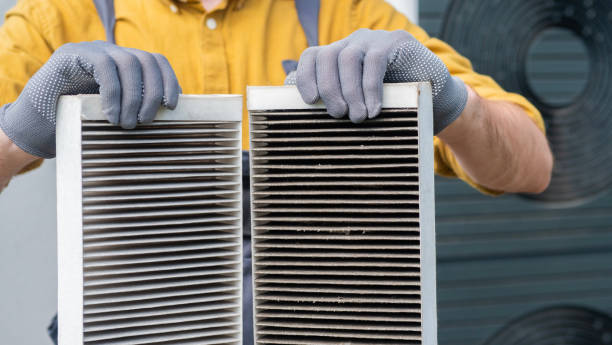 istock Worker holding two dirty air filters from a home ventilation system. 2156226177