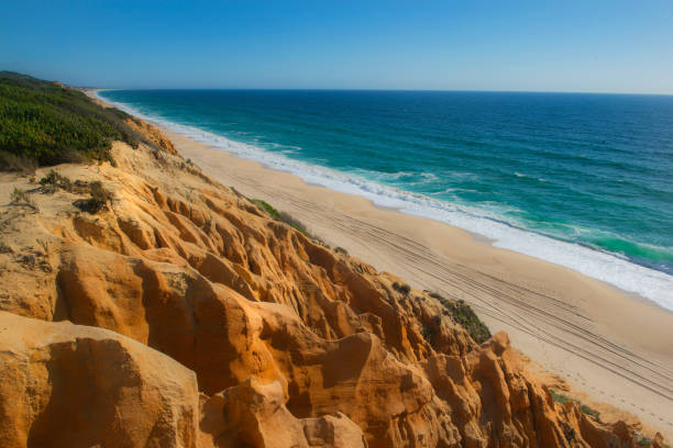 istock beautiful beach in the Atlantic Ocean bordered by hard sand cliffs forming a canyon Medides beach in Portugal 2156227453