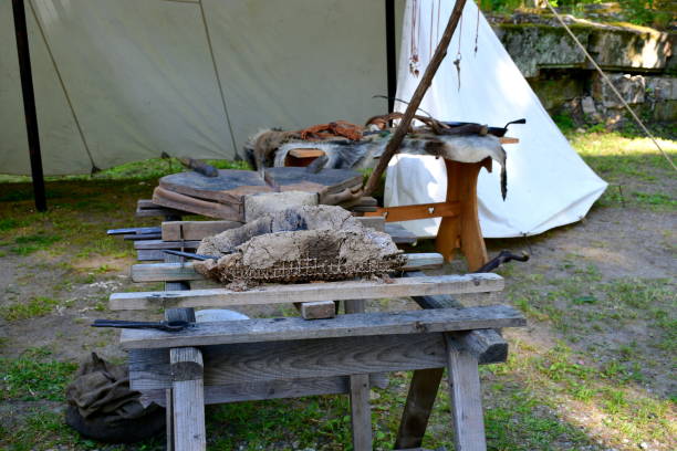 A small cloth tent being a temporary workstation of a blacksmith with all the key tools displayed, including grinder, worktable, anvil, hammer, and other equipment typical for medieval artisans