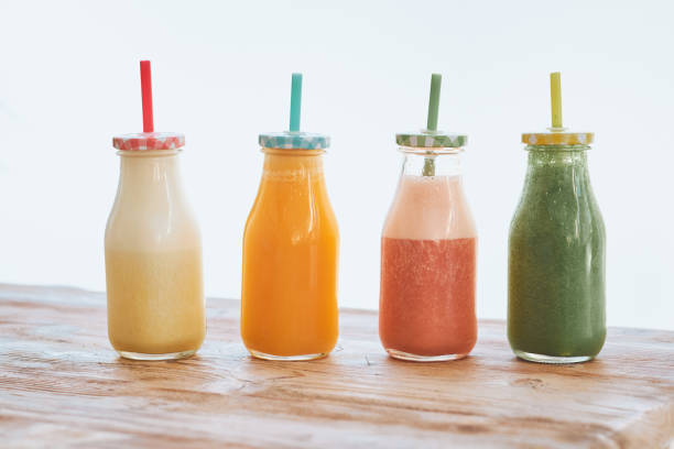 istock Bottles of yummy smoothies on wooden table 2156228916
