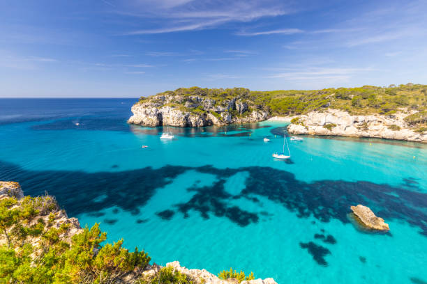 istock Macarella beach on the coast of Menorca, beautiful seaside landscape, white cliffs, turquoise sea, picturesque place for a holiday in Spain 2156229204