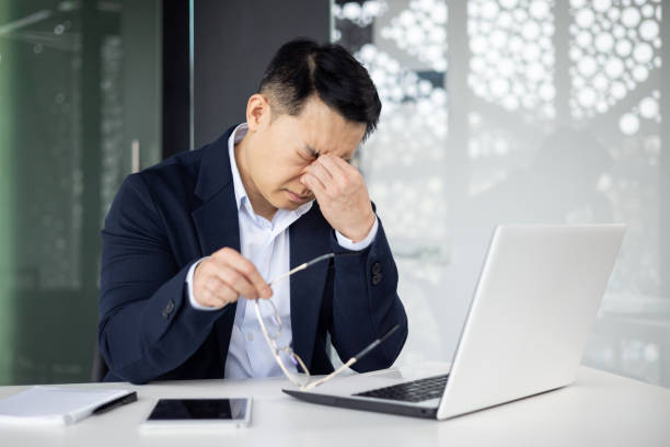 istock Stressed businessman feeling tired and massaging nose bridge 2156231968