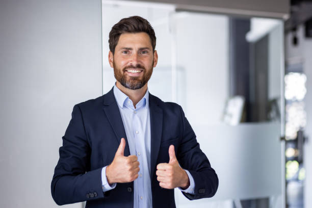 istock Confident business executive giving a thumbs up in modern office 2156232971