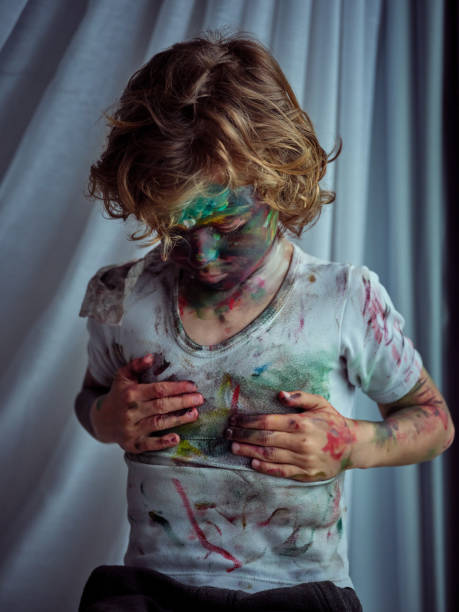 istock Dirty boy wiping paint on t shirt 2156234135