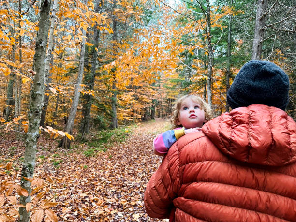 Father and daughter walk in an autumn forest in up state New York