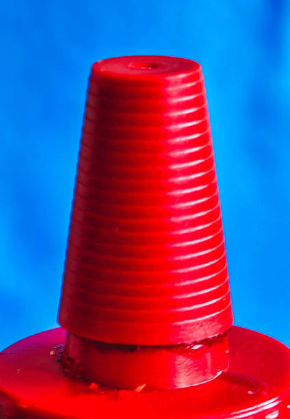 Bright red top of a bottle against a blue background