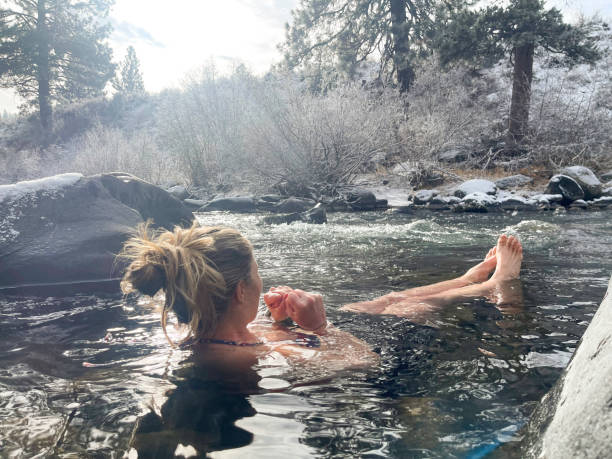Woman cold plunging in winter river