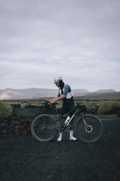 istock Road bicyclist pauses in rural landscape 2156237698