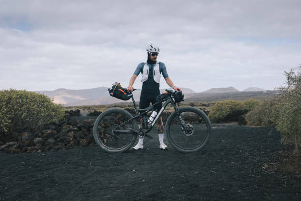 Road bicyclist pauses in rural landscape