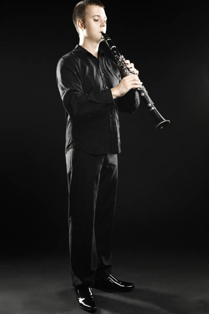 istock Clarinet player classical musician. Man playing clarinette woodwind instrument 2156241120