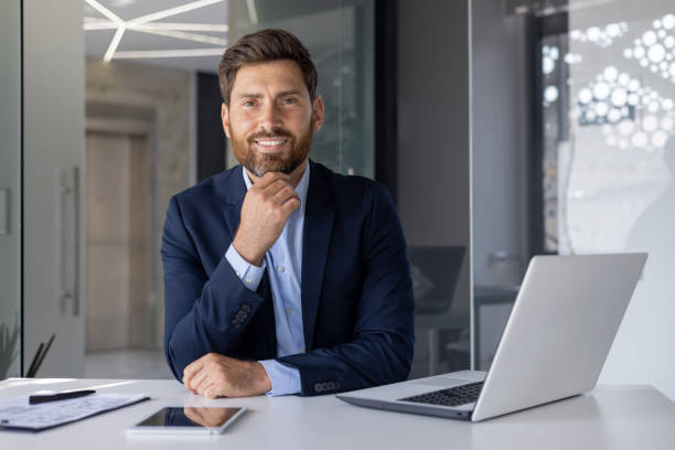 istock Confident businessman smiling at desk with laptop 2156241314