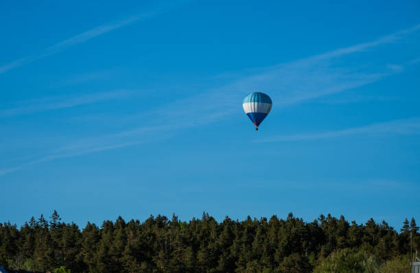 Blue white and red hot air balloon in evening sun.