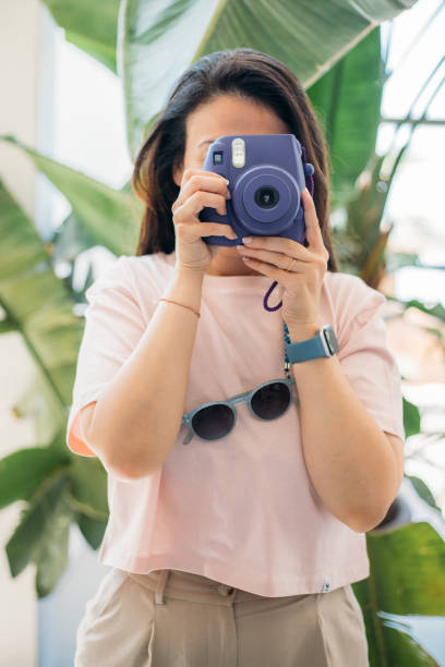 istock Woman taking photos with instant camera 2156247325