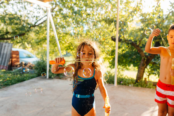 istock Children having fun making soap bubbles in the yard 2156250795