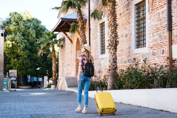 istock Tourist standing near historical building with suitcase 2156250818
