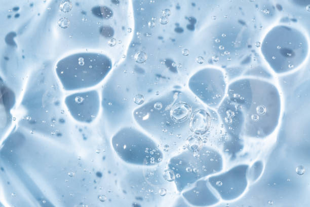 istock Abstract cosmetic background from transparent gel or antiseptic, hyaluron, macro close up, blue background 2156251421