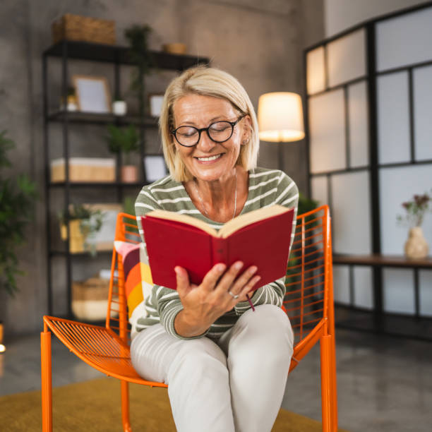 istock Mature senior woman sit at home and read a book 2156254376