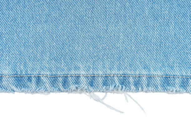 Blue denim jeans pants edge isolated on white background, close up, macro. Blue denim jeans pants edge isolated on white background, close up, macro. Ripped jeans stich, destroyed torn. Wallpaper, backdrop, design detail. fabric edge stock pictures, royalty-free photos & images