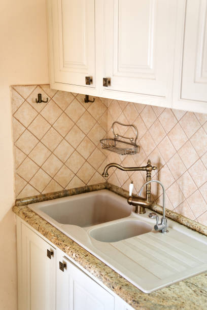 istock Double sink with bronze taps is embedded in a white table in the kitchen 2156255551