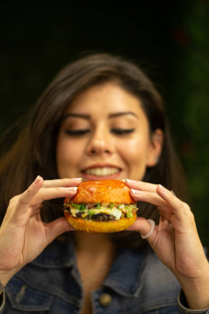 istock A happy young woman eating a burger 2156257022