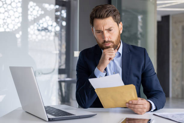 istock Serious businessman thinking over paperwork at office 2156257533