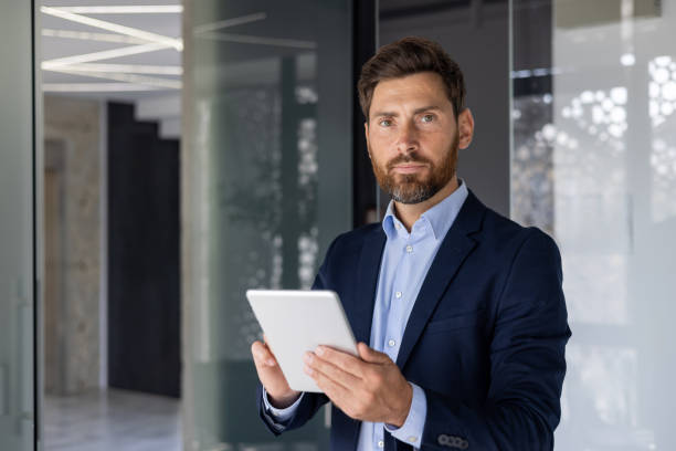 istock Confident businessman with tablet in modern office setting 2156258489
