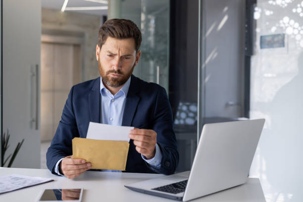 istock Serious businessman reviewing documents in modern office 2156259539