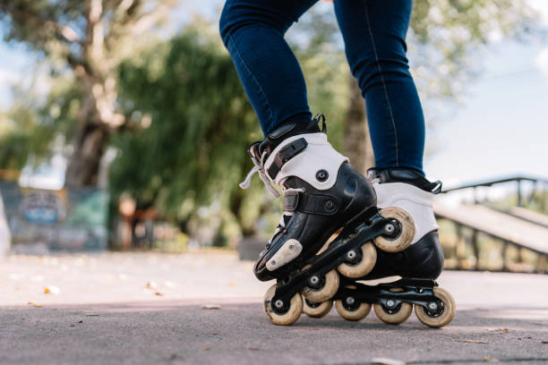 A woman is riding a roller skate on a sidewalk. Concept of freedom and enjoyment as the woman glides along the pavement
