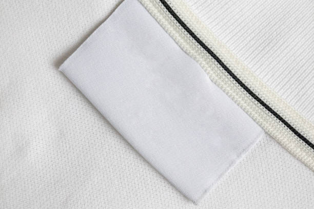 istock Blank white laundry care clothes label on white shirt fabric texture background 2156261711