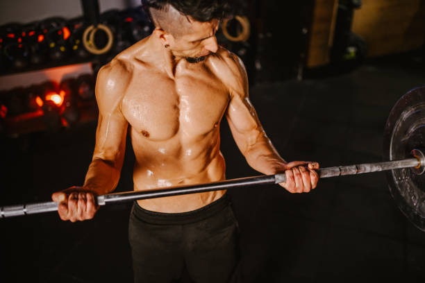 istock High angle shot of a muscular man lifting barbell while training in a gym 2156262060