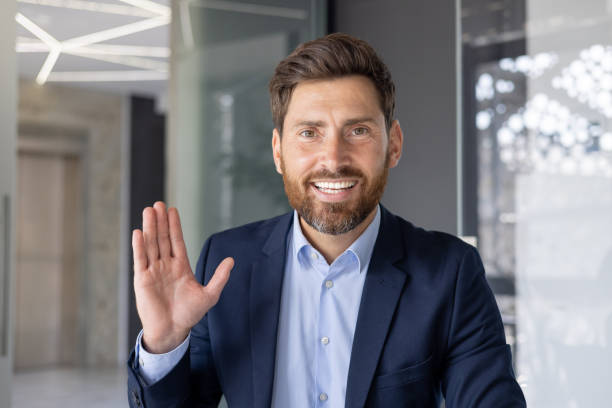 istock Friendly businessman waving hello in modern office 2156263726