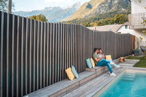 Happy woman in bikini relaxes, sunbathing and swimming with steams in the well-heated sitting and walks by the endless swimming hotel pool on top sunny spring day. This high infinity luxurious sky pool overlooking nature landscape panorama view in Alpin, Dolomiti, Italia
