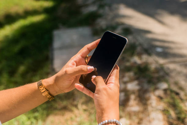 woman's hands outdoors holding and interacting with her mobile phone
