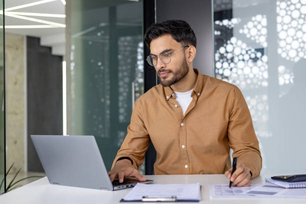 istock Businessman working on laptop in modern office environment 2156265000