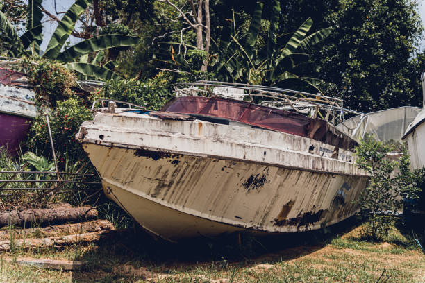 istock Old and rusty motor boats on a landfill surrounded by tropical forest 2156265029