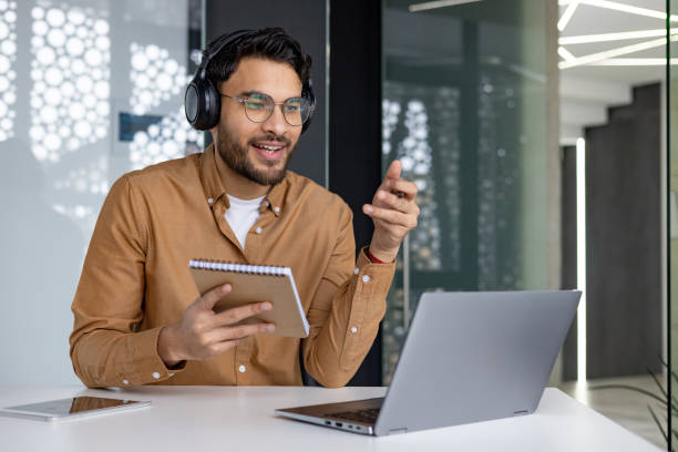 istock Man attending online webinar and taking notes at modern office desk 2156268174