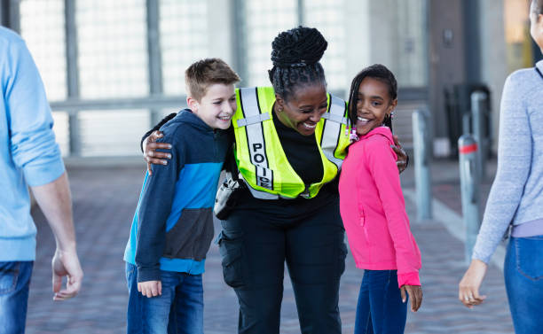 istock Policewoman greeting multiracial children with hugs 2156271833
