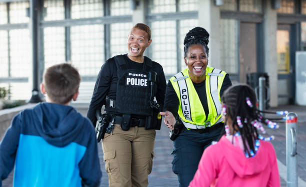 istock Two policewomen greeting two children 2156271839