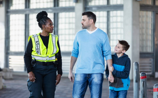istock African-American policewoman talking with father, son 2156271909