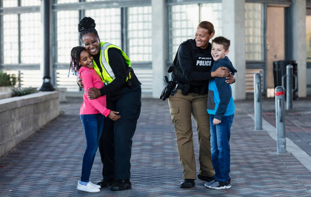 istock Two policewomen greeting two children 2156271920