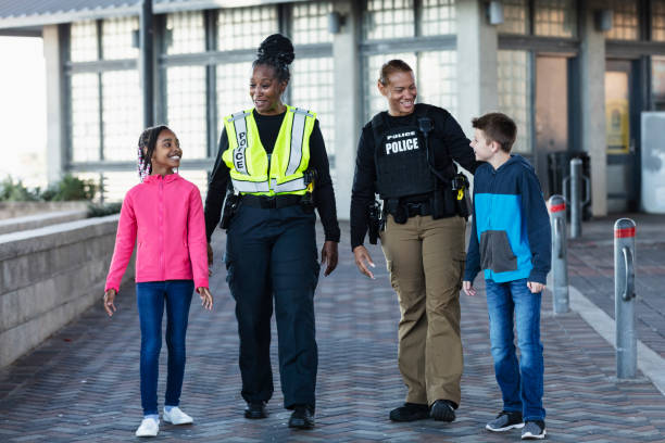istock Two policewomen walking with two children 2156271927