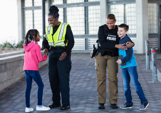 istock Two policewomen greeting two children 2156271934
