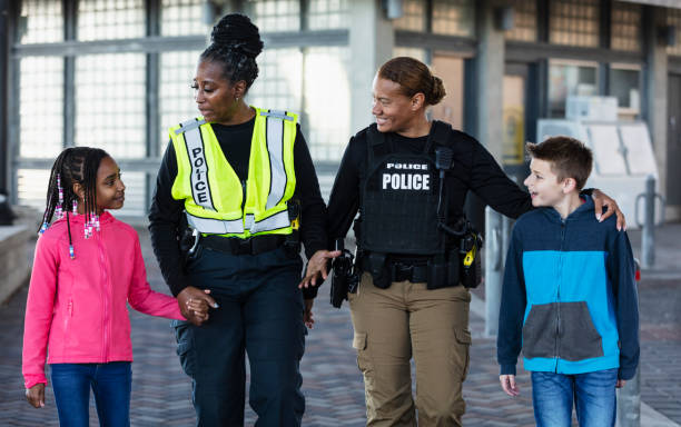 istock Two policewomen walking with two children 2156271942