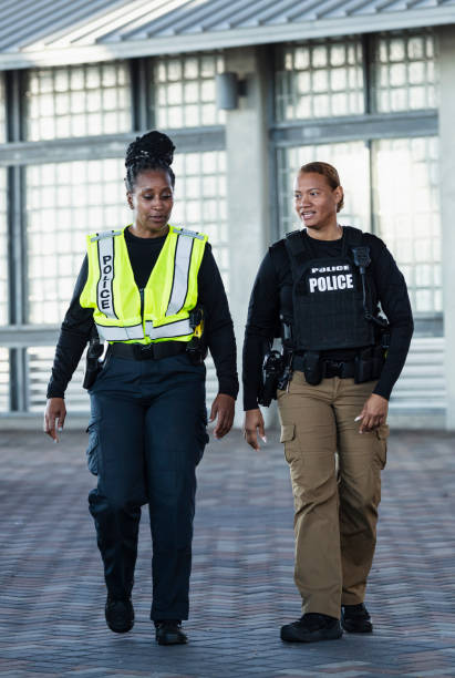 istock Two multiracial policewomen conversing, on foot patrol 2156271946