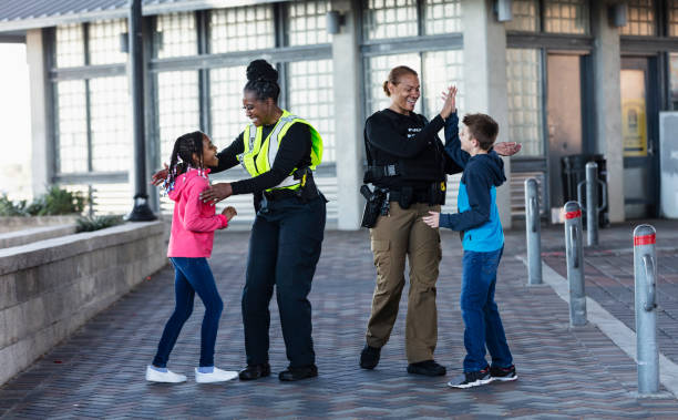 istock Two policewomen greeting two children 2156271953