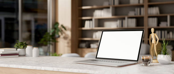 istock A laptop computer mockup on a table in a contemporary spacious living room or private office. 2156274342