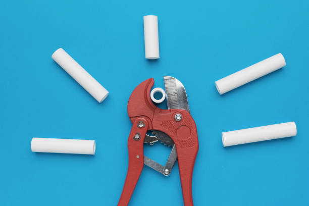 istock Plumbing Pipe Cutter Tool with White PVC Pipe Pieces on Blue Background 2156275677