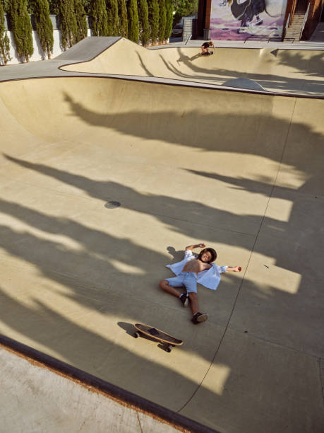 istock Boy with longboard fell in skate park 2156284216