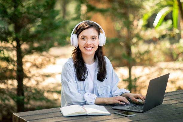 istock Smiling woman working with laptop in nature 2156284512