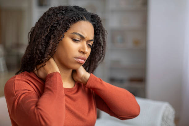 istock Young Black Female Suffering Neck Pain While Sitting On Couch At Home 2156287704